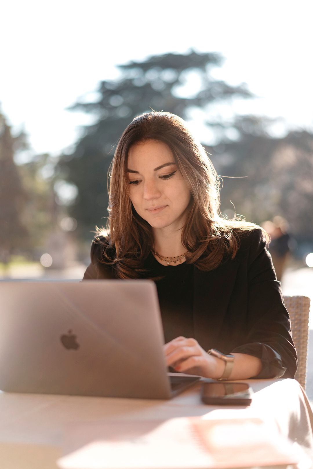Francesca Zecchin working at her laptop outdoors, focused and composed